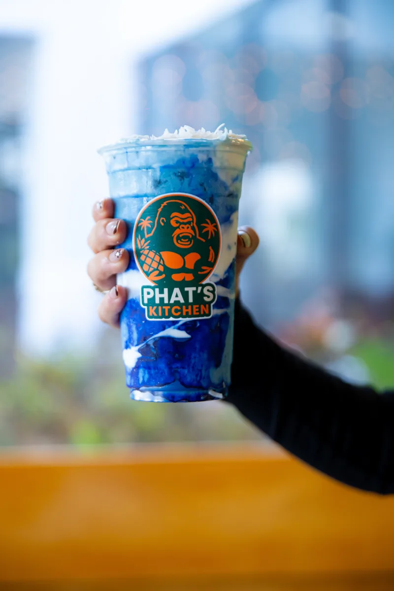 Blue Spirulina smoothie — electric blue, held up outside the shop